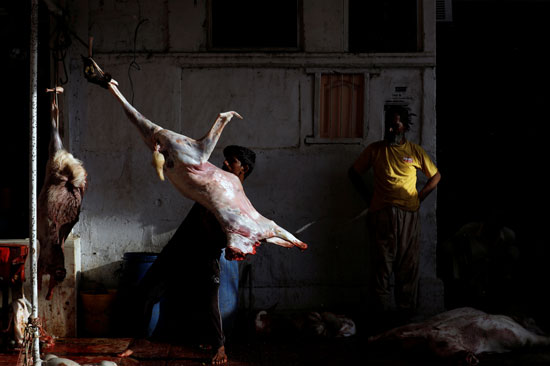 رجل يحمل لحم الماعز بعد أن قشره ، في أحد المتاجر ، خلال الاحتفال بعيد الأضحى