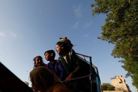 الأطفال يحتفلون بالعيد فوق أرجوحة في حي بكراتشي
