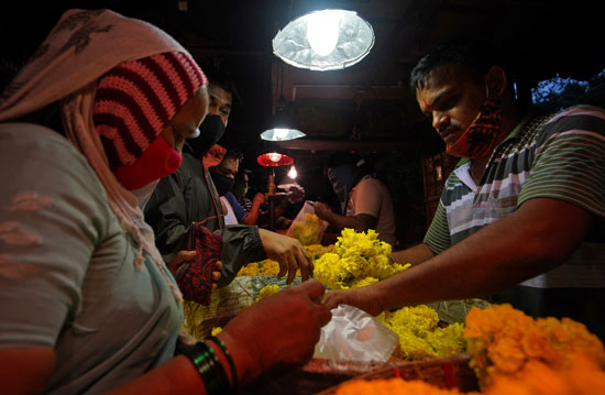 الهنود يشترون الزهور لتزيين تمثال جانيش