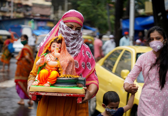امرأة تحمل تمثالًا للإله الهندوسي جانيش