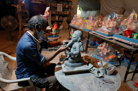 فنان هندي يقوم بنحت تمثال جانيش