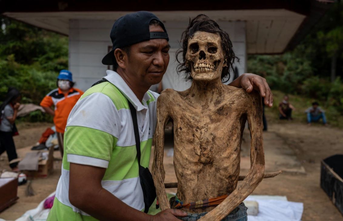 إندونيسي يلتقط صورة مع جثة