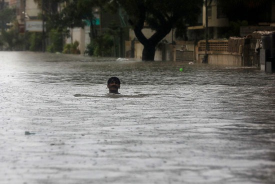 رجل يسبح وسط المياه التي غمرت المدينة