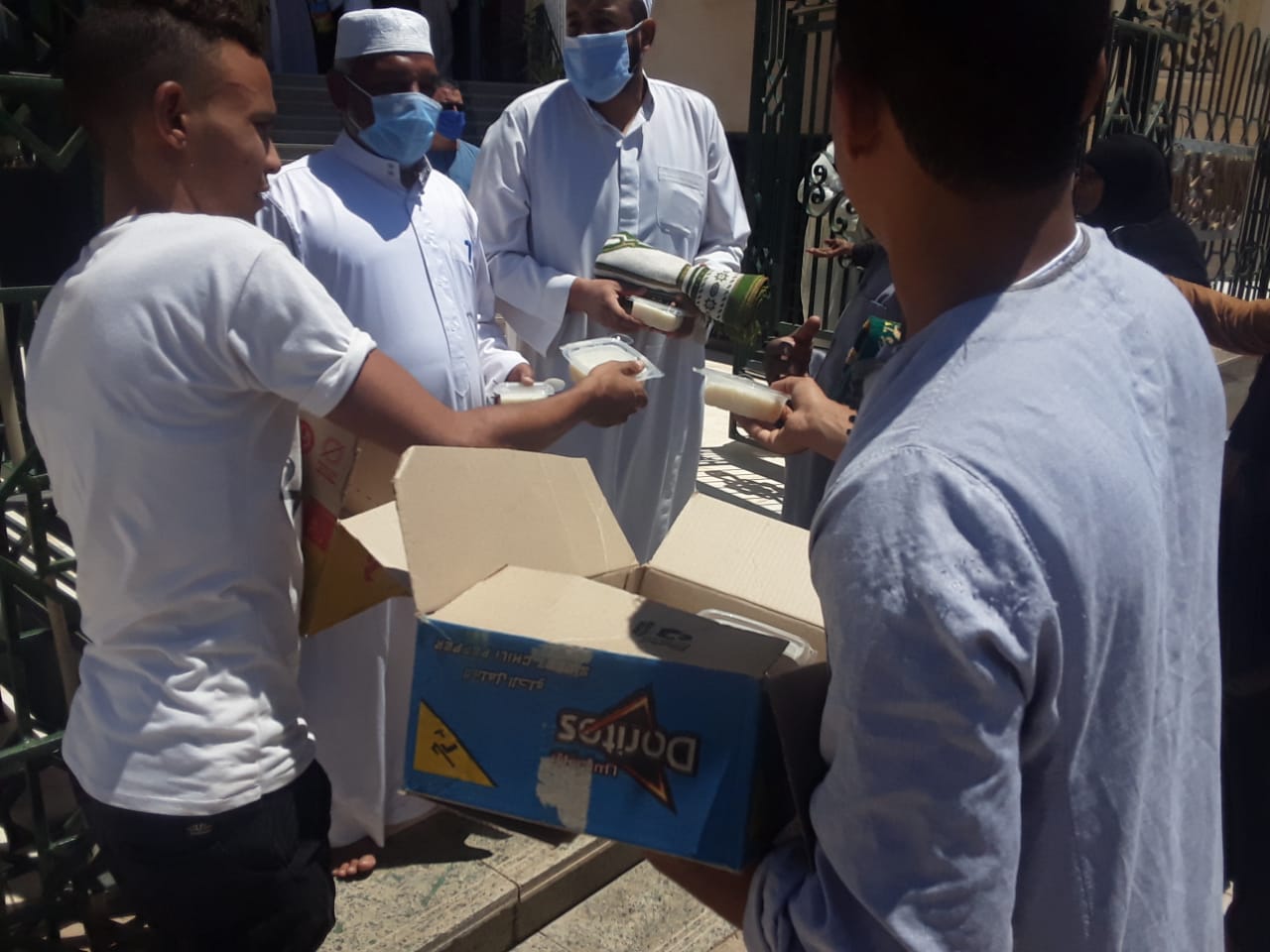 مواطنون يوزعون حلوى وأرز بلبن احتفالا بفتح المساجد لصلاة الجمعة فى أسوان (1)