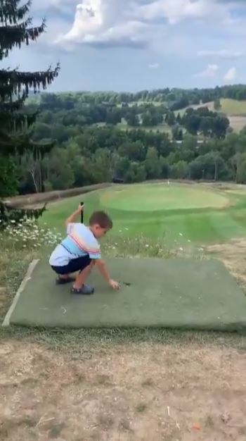 طفل يدخل كرة الجولف في الحفرة