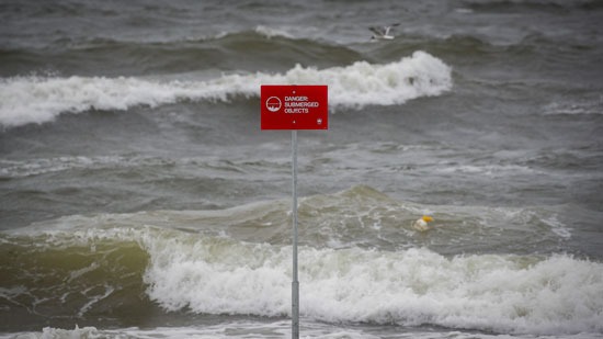 علامة الخطر مع ارتفاع الأمواج على الشاطئ