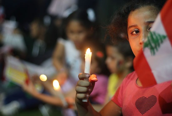 طفلة فلسطينية تحمل الشمعة تضامنًا مه ضحايا انفجار بيروت