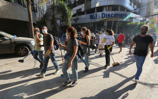 لبنانيون فى طريقهم لموقع الانفجار لازالة اثاره وتنظيف الشوارع