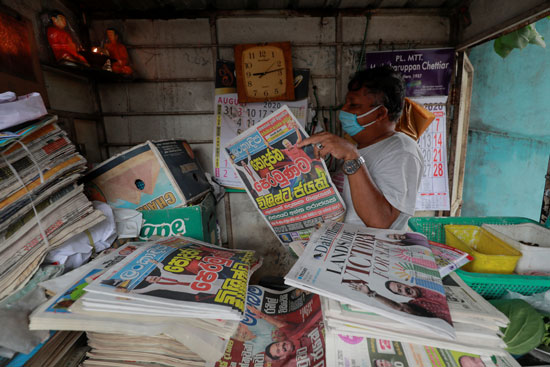 رجل يقرأ صحيفة تحمل عنوانًا رئيسيًا عن فوز حزب الجبهة الشعبية السريلانكية بزعامة ماهيندا راجاباكسا في الانتخابات البرلمانية للبلاد في كولومبو