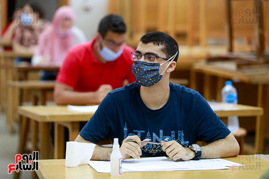 طلاب مرتدين الكمامات أثناء اداء الاختبارات