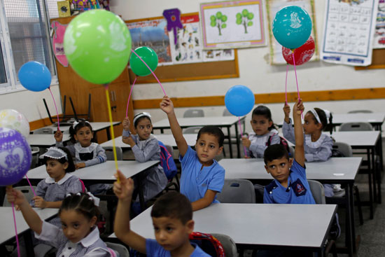 طلاب فلسطينيون يحملون بالونات