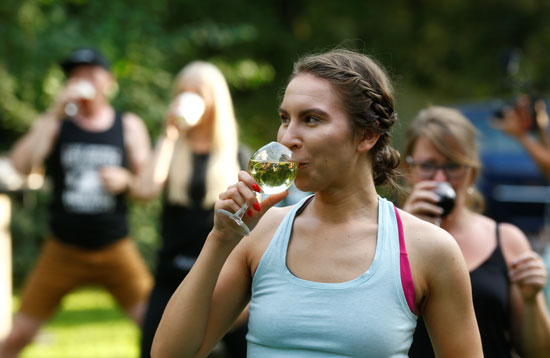 سيدة تشرب النبيذ خلال ممارسة اليوجا