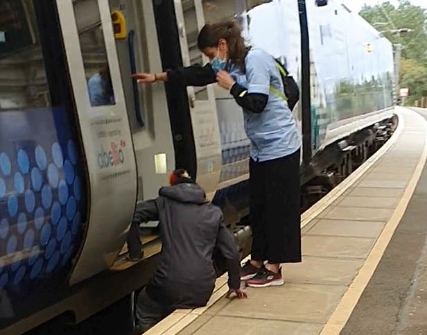 امرأة تنزل تحت القطار الالتقاط أشياء سقطت منها بالمملكة المتحدة (1)