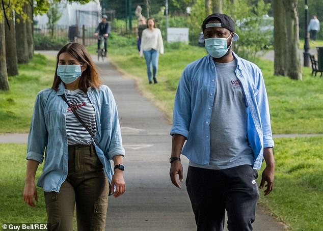 27401736-8243385-Two_people_wear_masks_while_walking_through_Clapham_Common_in_So-a-36_1587537204533