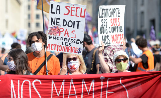 لافتة كتب عليها الرأسمالية هي الفيروس خلال مسيرة نظمها عمال الصحة العامة البلجيكيون (2)