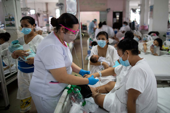 الممرضة الفلبينية مارشيانا إيريسبي تعتني بأم داخل جناح الولادة