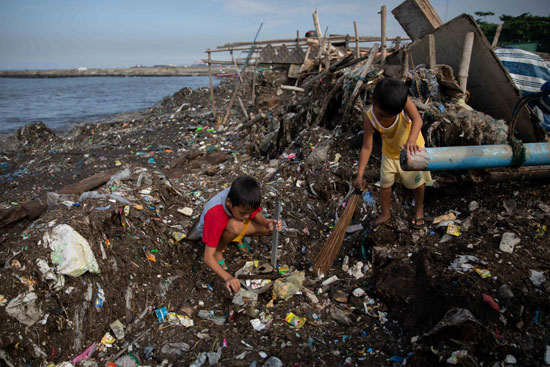 طفلان يشاركان في اليوم الدولي لتنظيف السواحل