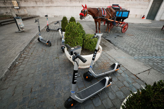 دراجات كهربائية وعربة بحصان قرب  نصب فيتوريانو التذكاري في ساحة فينيسيا