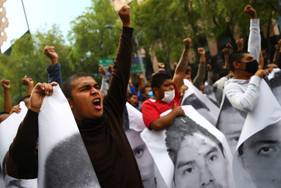 متظاهرون يحملون صور الطلاب الذين تم اختطافهم