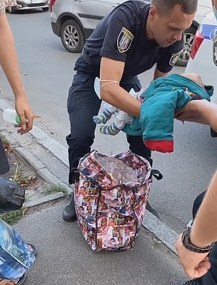 ضابط الشرطة يحتفظ بالطفل حتى مجيىء سيارة آسعاف