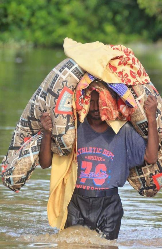 رجل يجمل بعض المفروشات وسط الفيضانات