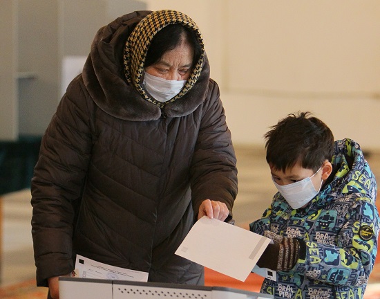 طفل يشارك أمه في التصويت
