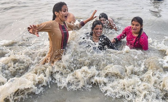 فتيات يقمن بالغطس المقدس في نهر جانجا