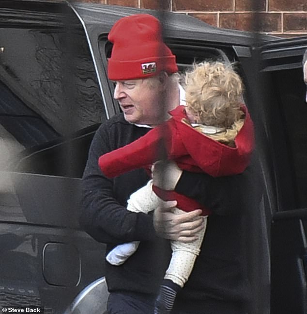 بوريس جونسون يحمل ابنه