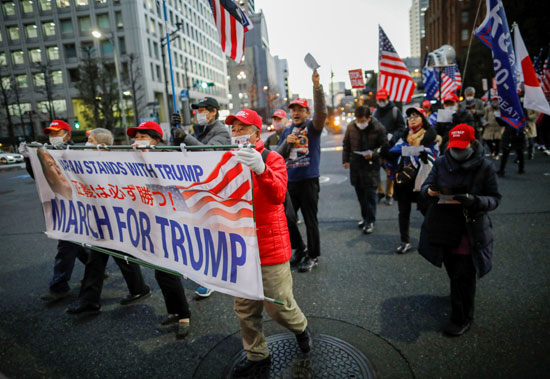 اليابان تقف إلى جانب ترامب.. شعار على أحد اللافتات فى مسيرة بطوكيو