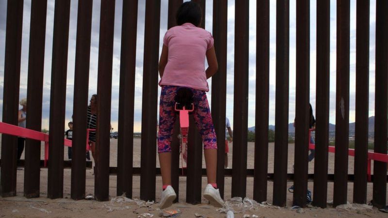 طفل يلعب على أرجوحة بين أمريكا والمكسيك