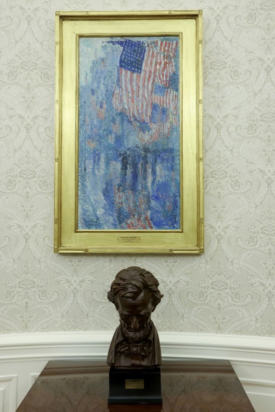 تمثال نصفي للرئيس أبراهام لينكولن يجلس تحت لوحة للأعلام الأمريكية