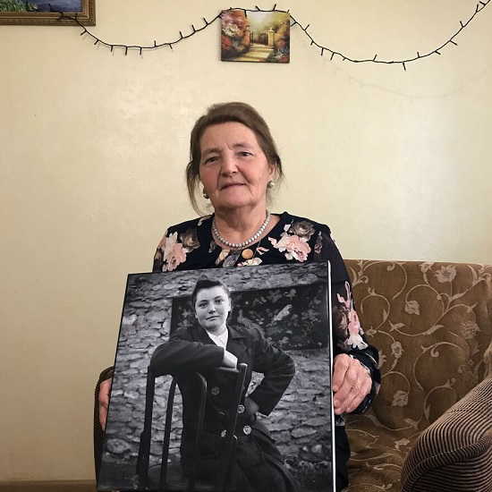 سيدة سبعينية مع صورتها في العشرينيات