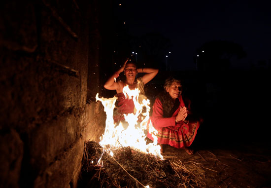 مواطنو نيبال يشعلون النيران للتدفئة أثناء ممارسة الطقوس