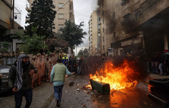 متظاهرون مناهضون للحكومة يحرقون القمامة أثناء تجولهم حول منازل النواب