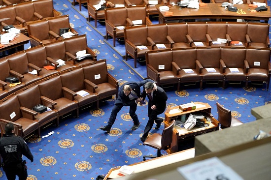 يحاول أعضاء الكونجرس الاختباء بينما يحاول المتظاهرون دخول قاعة