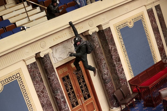 متظاهر يتدلى من الشرفة في قاعة مجلس الشيوخ