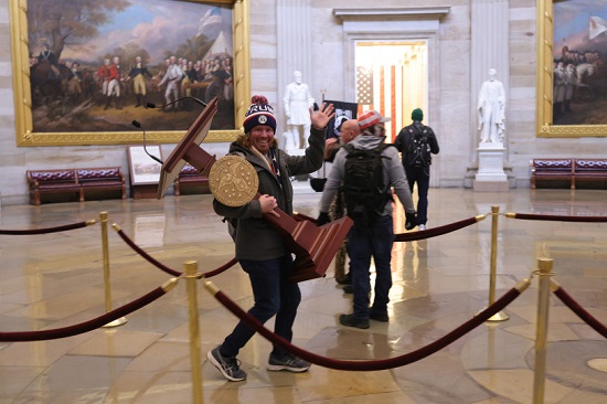 متظاهر يحمل منصة داخل مبنى الكابيتول الأمريكي