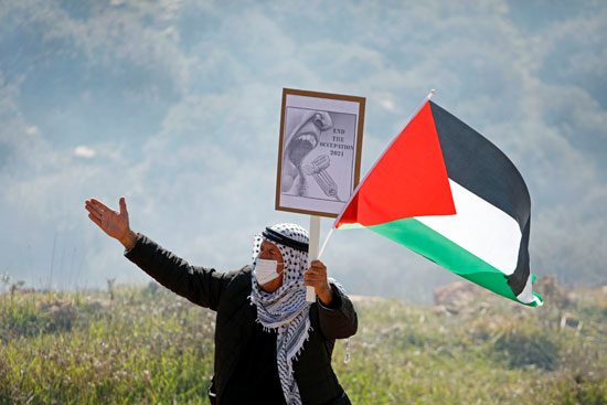 مسن يرفع علم فلسطين