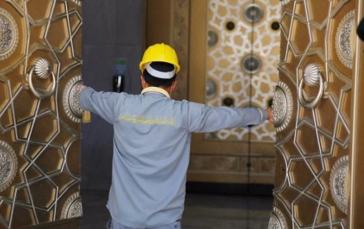 عامل يفتح باب المسجد