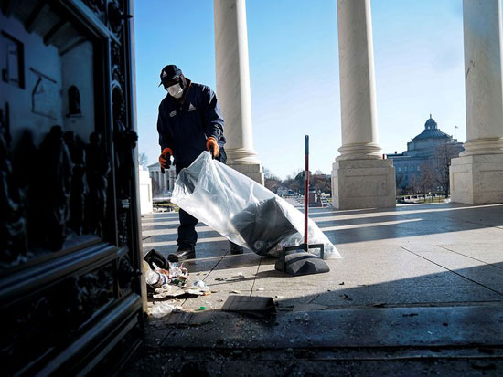 عامل ينظف الأنقاض خارج مبنى الكابيتول الأمريكي