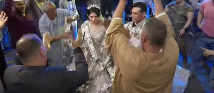 جانب من وضع عناقيد الاموال في عنف العريس والعروس جانب من وضع عناقيد الاموال في عنف العريس والعروس