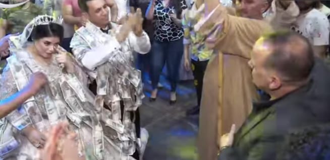 جانب من وضع العناقيد للعريس والعروس جانب من وضع العناقيد للعريس والعروس