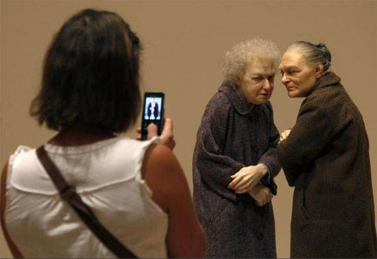 امرأة تلتقط صورة لمنحوتة بعنوان امرأتان لرون مويك