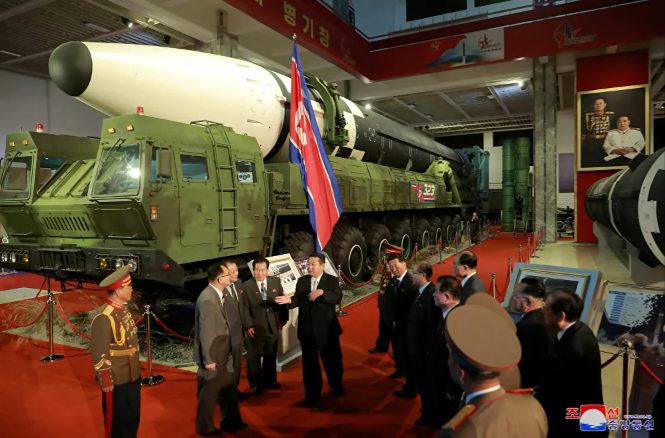 زعيم كوريا الشمالية كيم جونغ أون و المسؤولين بجوار الأسلحة والمركبات العسكرية ا