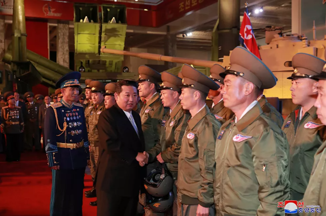 زعيم كوريا الشمالية  يتحدث إلى المسؤولين بجوار الأسلحة والمركبات العسكرية