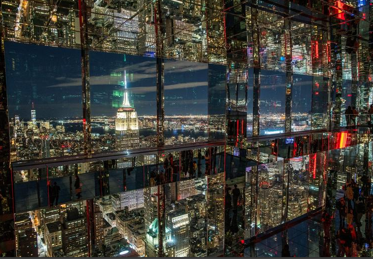 يحضر الناس معاينة سطح المراقبةمن برج في وسط مانهاتن ، في نيويورك
