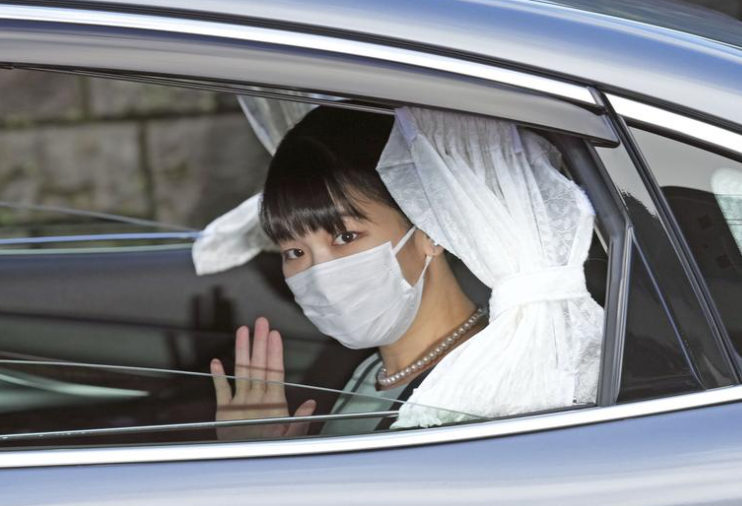 الأميرة اليابانية ماكو تلوح من داخل سيارة وهي تغادر منزلها من أجل زواجها