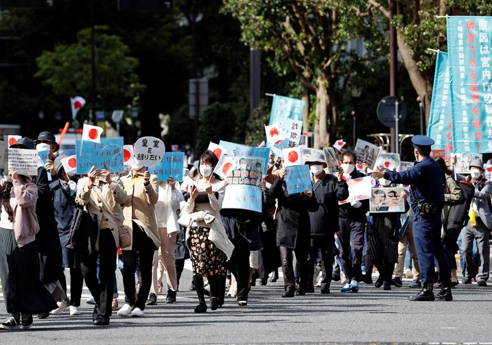 متظاهرون يحملون لافتات خلال مسيرة ضد زواج الأميرة اليابانية ماكو