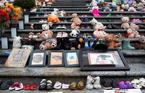 دمى الدببة والأحذية والأعمال الفنية والزهور في ذكرى ضحايا مدرسة كاملوبس السكنية
