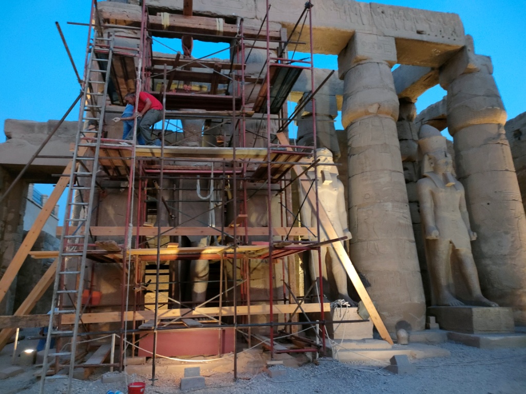 العمل فى ترميمات تماثيل رمسيس الثانى بالجهة الغربية للفناء الأول بالمعبد (3)